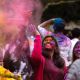 A photograph of students throwing coloured powders