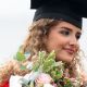 Student in a Graduation gown holding flowers